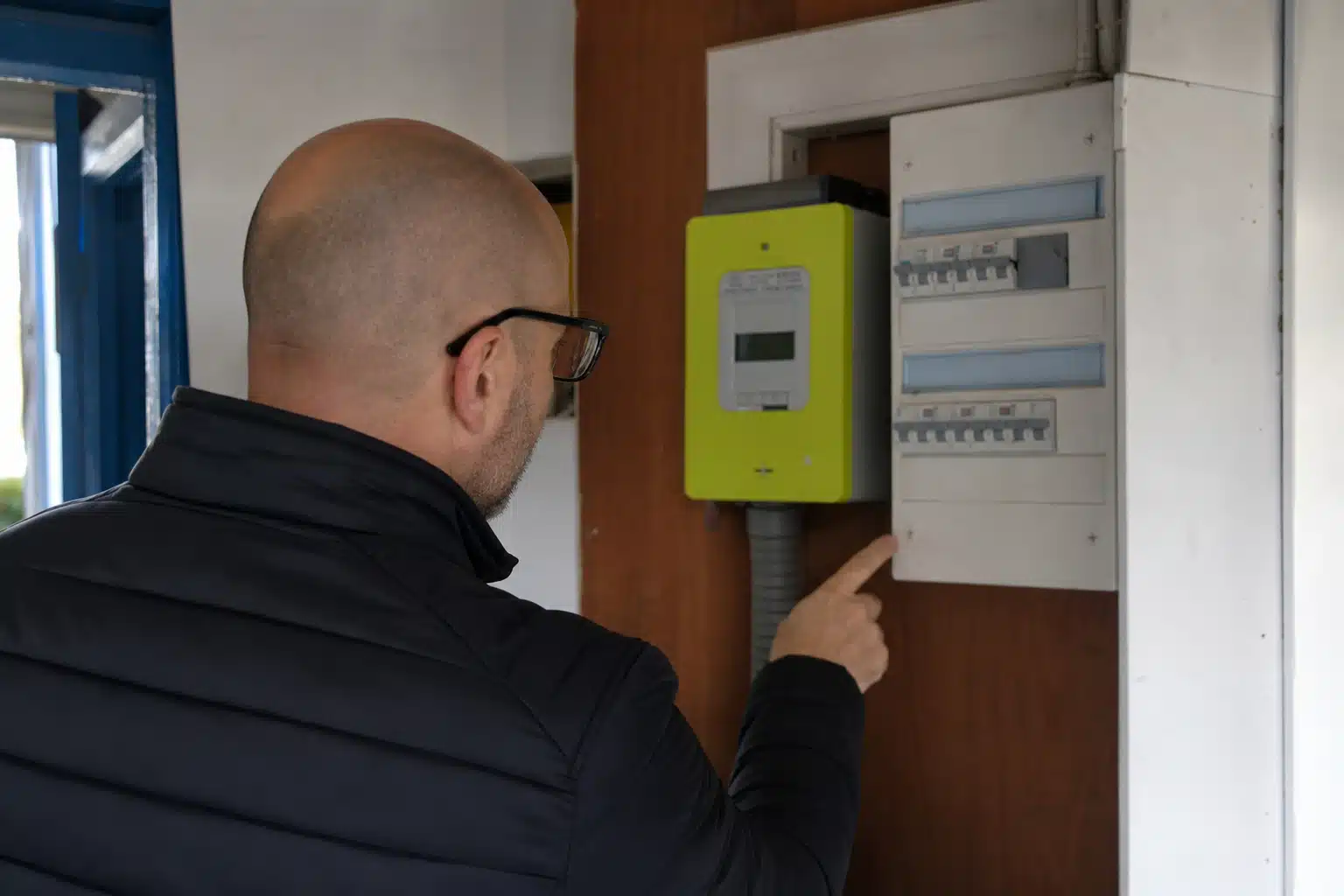 Personne pointant un appareil électrique vert sur tableau